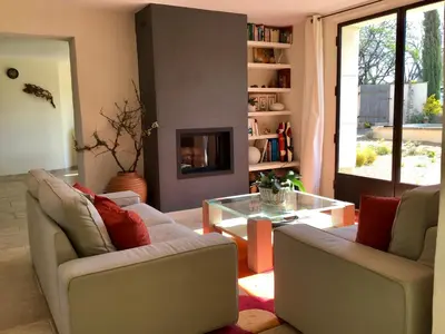 a living room with two chairs and a coffee table at Mas du Figuier Oppede Luberon in Oppède