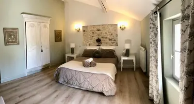 a bedroom with a bed and two tables and a window at La Bri...Gite in LʼIsle-sur-la-Sorgue