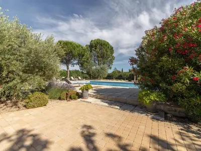a swimming pool in a yard with bushes and trees at Relaxing Provence Hideaway in Carpentras