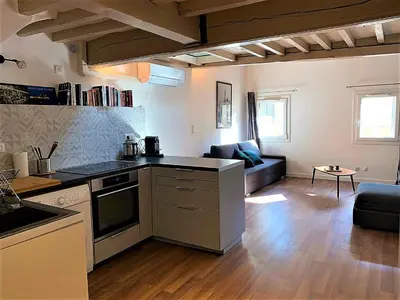 a kitchen and living room with a couch and a table at LE FOCH in Aix-en-Provence