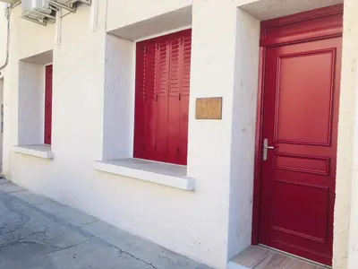 a red door on the side of a building at Les volets rouges in Cavaillon