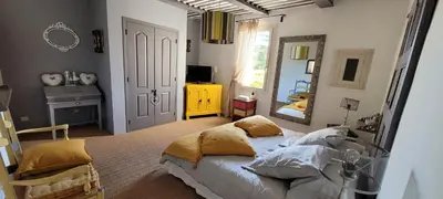 a bedroom with a bed with pillows and a mirror at Mas La Pomarede in Robion en Luberon