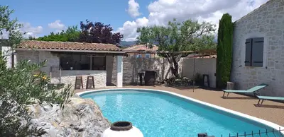 a swimming pool in front of a house at Un petit coin de paradis in Modène