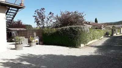a hedge in front of a house with a driveway at Un petit coin de paradis in Modène