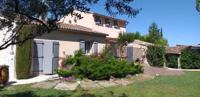 a white house with a gate and a yard at Un petit coin de paradis in Modène