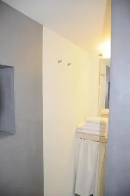 a white room with a bed and a mirror at Villa Vagabonde in Gordes