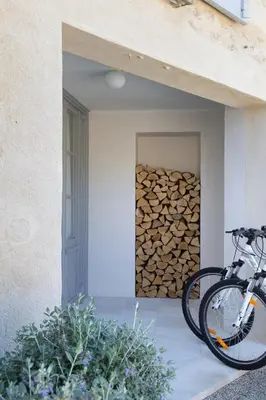 a bike parked next to a pile of fire wood at Villa Vagabonde in Gordes