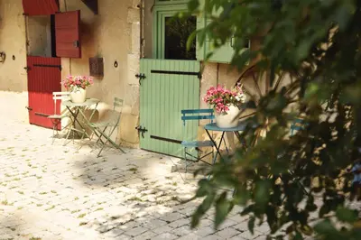 a group of chairs and a door with flowers on them at Embarben Maison d'hôtes in Saint-Chamas