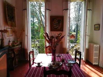 a dining room table with a vase of flowers on it at Embarben Maison d'hôtes in Saint-Chamas