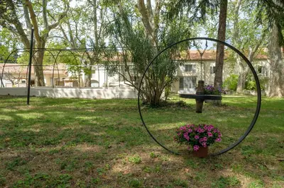 a tree with purple flowers in front of a house at Mas 9 Romanin - Mas Provençal Familial in Saint-Rémy-de-Provence