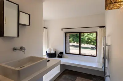 a white bathroom with a sink and a window at Le Domaine du Castellas in Sivergues