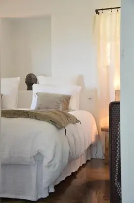 a bedroom with a bed with white sheets and pillows at Le Domaine du Castellas in Sivergues