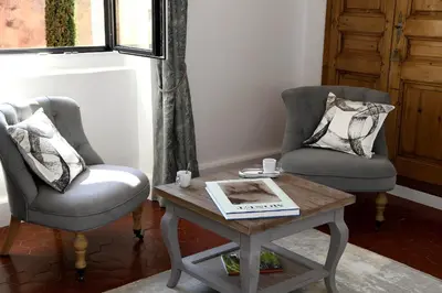 a living room with two chairs and a coffee table at Bastide Des Demoiselles in Roussillon