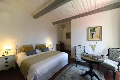 a bedroom with a bed and a table and chairs at Bastide Des Demoiselles in Roussillon