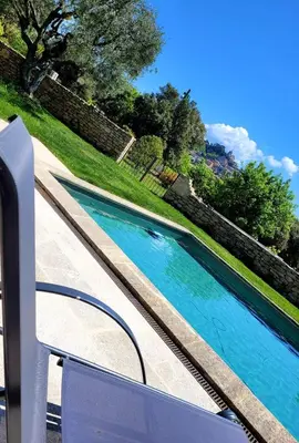 a swimming pool with blue water in a yard at Gardiole in Bonnieux