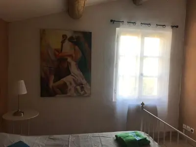 a bedroom with a painting on the wall and a bed at La Bastide de l'Olivier in Flassan