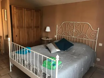 a bedroom with a bed with a white crib at La Bastide de l'Olivier in Flassan