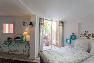 a bedroom with a bed and a table and a window at La maison de Tao in Aix-en-Provence