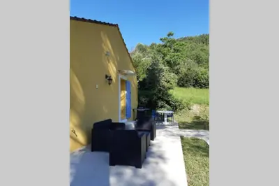a patio with black chairs and a building at Vue panoramique sur le château,montagne et grottes in Fontaine-de-Vaucluse