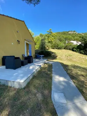 a patio with couches and a table in a yard at Vue panoramique sur le château,montagne et grottes in Fontaine-de-Vaucluse