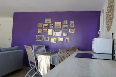 a dining room with a purple wall with a table and chairs at Studio charmant au calme in Aix-en-Provence