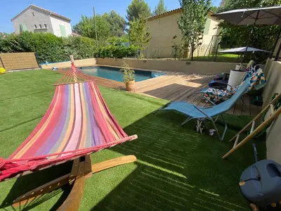 a colorful hammock in a yard next to a pool at Studio charmant au calme in Aix-en-Provence
