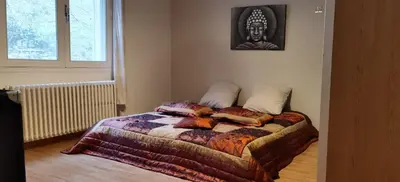 a bedroom with a bed with a statue on the wall at Loue haut de villa au calme piscine jardin arboré in Cornillon-Confoux