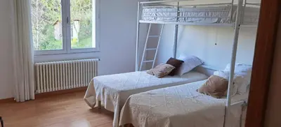 a bedroom with two bunk beds and a window at Loue haut de villa au calme piscine jardin arboré in Cornillon-Confoux