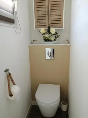 a bathroom with a toilet with a toilet paper dispenser at La perle des Alpilles Résidence les MYRTILLES in Eyguières