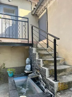 a stairway with a statue sitting next to a building at Appartement St Victor in Puyvert