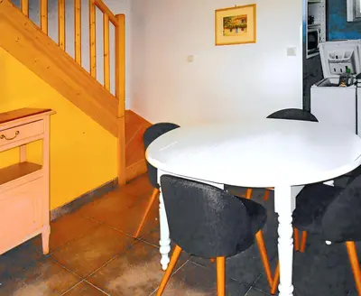 a white table and chairs in a room with a staircase at Appartement lumineux à Lançon-Provence, piscine partagée in Lançon-Provence