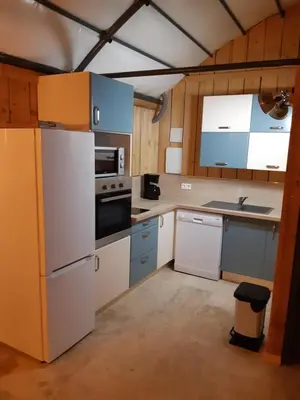 a kitchen with white appliances and blue cabinets at DANSAVAN Chambres d Hôtes Gite in Oppède