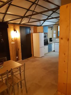 a kitchen with a table and a white refrigerator at DANSAVAN Chambres d Hôtes Gite in Oppède