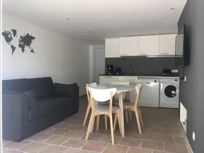 a living room with a couch and a table and chairs at Duplex pour 2 à 4 personnes avec piscine au coeur des vignes in Pélissanne