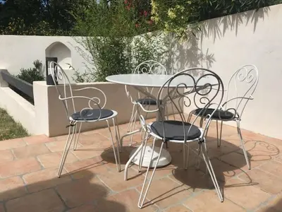 three chairs and a table and a table and chairs at Duplex pour 2 à 4 personnes avec piscine au coeur des vignes in Pélissanne