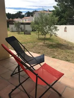 a black and red chair sitting on a porch at Duplex pour 2 à 4 personnes avec piscine au coeur des vignes in Pélissanne