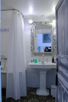 a bathroom with a white shower curtain and a sink at Les Volets Bleus Provence in Salon-de-Provence