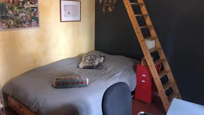 a bed in a room with a wooden ladder at Les Volets Bleus Provence in Salon-de-Provence