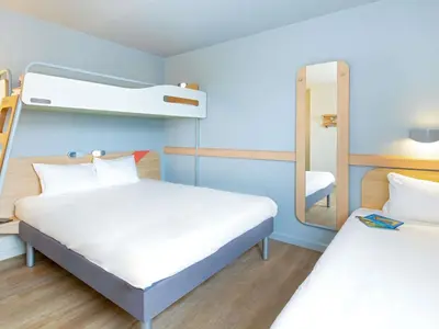 a room with two bunk beds and a mirror at ibis budget Cavaillon in Cavaillon
