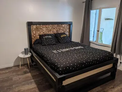 a bedroom with a black bed with a window at Maison dans quartier calme in LʼIsle-sur-la-Sorgue