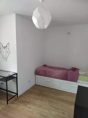 a white room with a bed and a table at Maison dans quartier calme in LʼIsle-sur-la-Sorgue