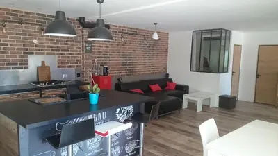 a living room with a couch and a brick wall at Maison dans quartier calme in LʼIsle-sur-la-Sorgue