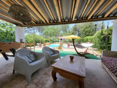 a living room with chairs and a table and an umbrella at Le Phoenix de Sainte Victoire in Saint-Marc-Jaumegarde