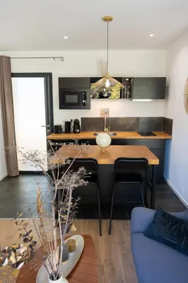 a kitchen with a table and a blue couch at Le Phoenix de Sainte Victoire in Saint-Marc-Jaumegarde