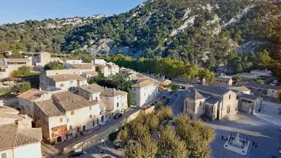 an aerial view of a village with a mountain at la fée viviane et michel l'enchanteur in Robion en Luberon