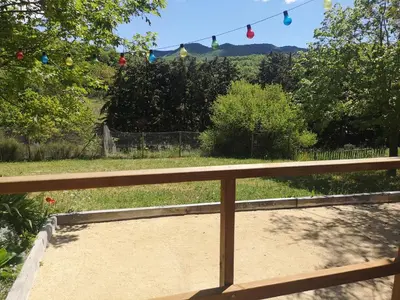 a porch with a view of a yard with a fence at Roulotte la clé du Luberon in Buoux