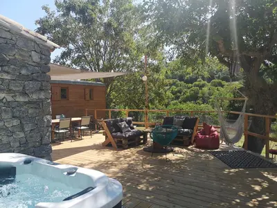a patio with a hot tub and chairs and a table at Roulotte la clé du Luberon in Buoux