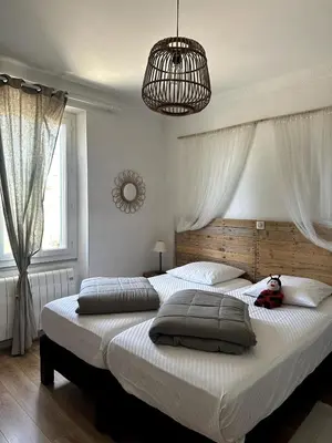a bedroom with two beds and a chandelier at Ocra Pure in Roussillon