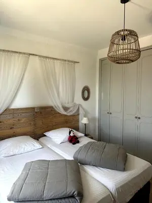 a teddy bear sitting on two beds in a bedroom at Ocra Pure in Roussillon