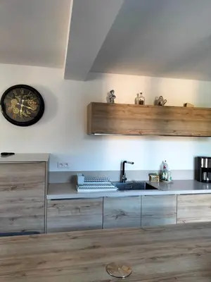a kitchen with a sink and a clock on the wall at Maison Provençale Spa Sauna Piscine in Mollégès